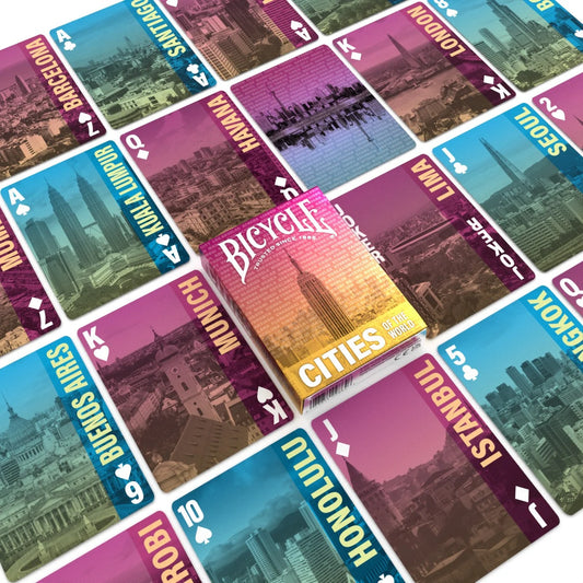 Collection of Bicycle Cities playing cards with various cityscapes on the card backs.