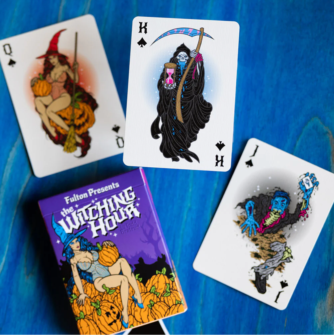 Playing cards with Halloween-themed designs on a blue surface