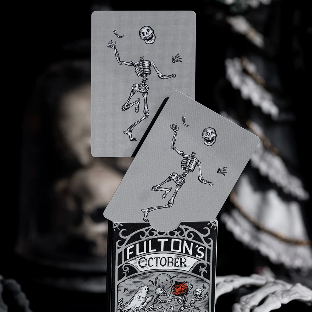 Playing cards with skeleton design and 'Fulton's October' branding on a dark background.