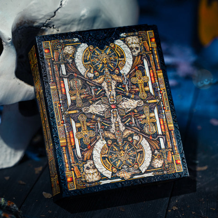Decorative box with intricate design on a dark surface with a skull and other objects.