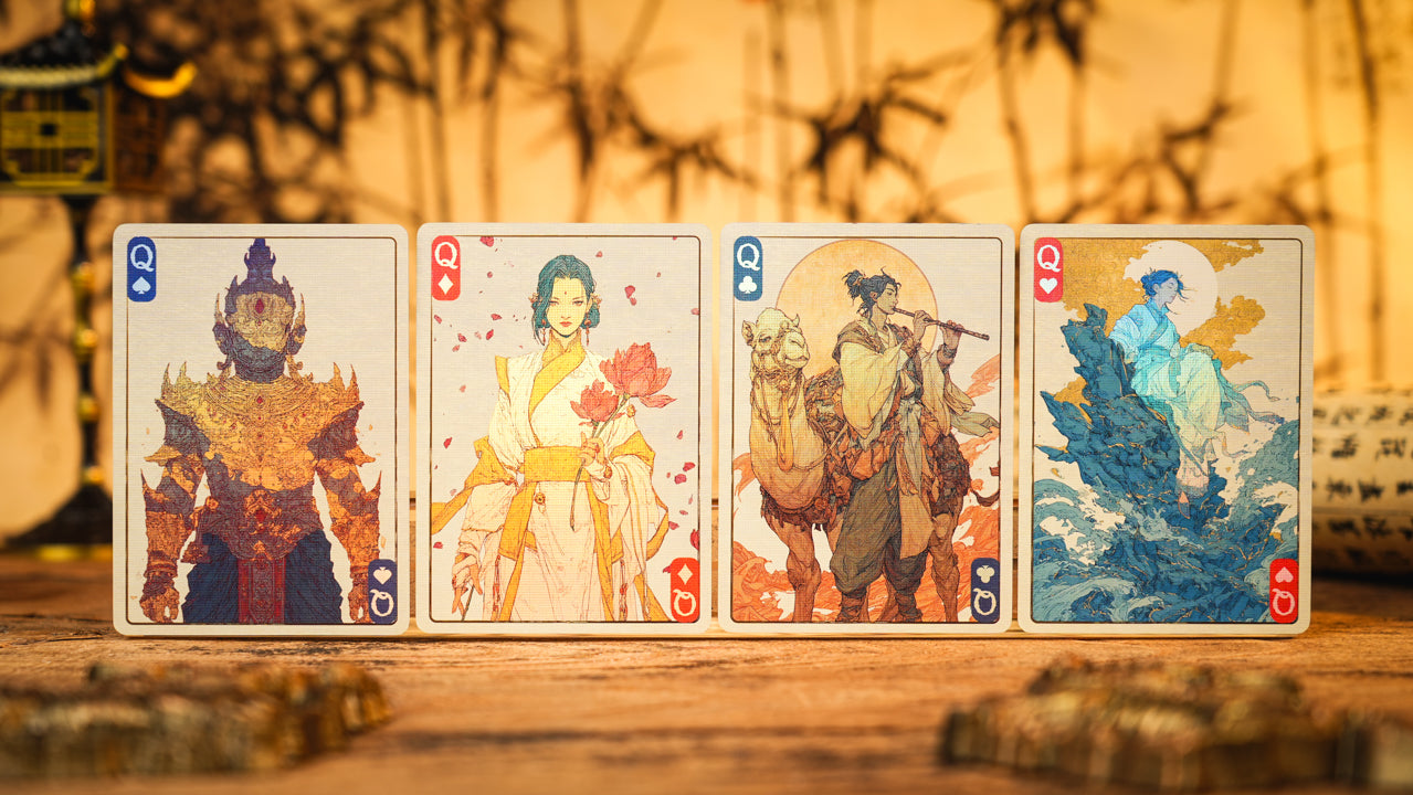 Four playing cards with illustrated characters on a wooden surface.