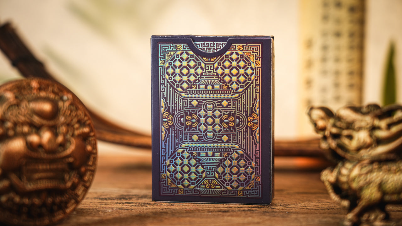 Decorative playing card box with intricate patterns on a wooden surface.