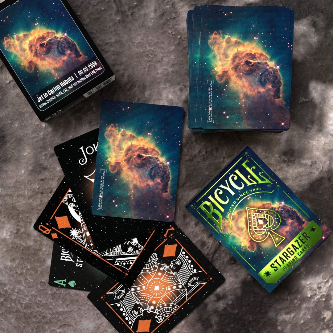 Bicycle Stargazer playing cards with nebula designs on a textured surface