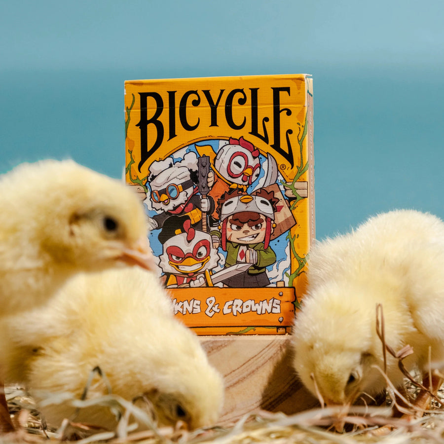 Bicycle card deck with cartoon characters on a blue background, surrounded by baby chicks.