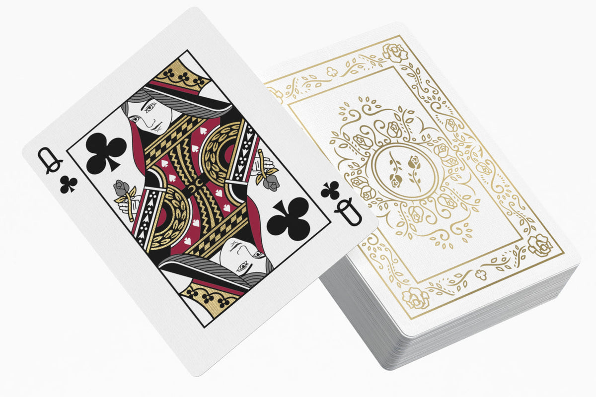 Black Roses White Gold Foil Edition Playing Cards with the Queen of Clubs face-up and the back of the deck visible behind it.