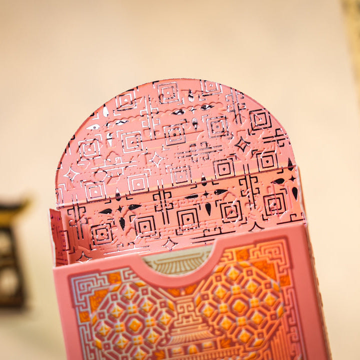 Decorative pink card with geometric patterns on a blurred background