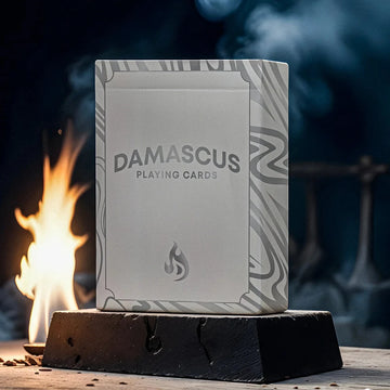 Pack of Damascus Playing Cards on a wooden stand with a fire in the background