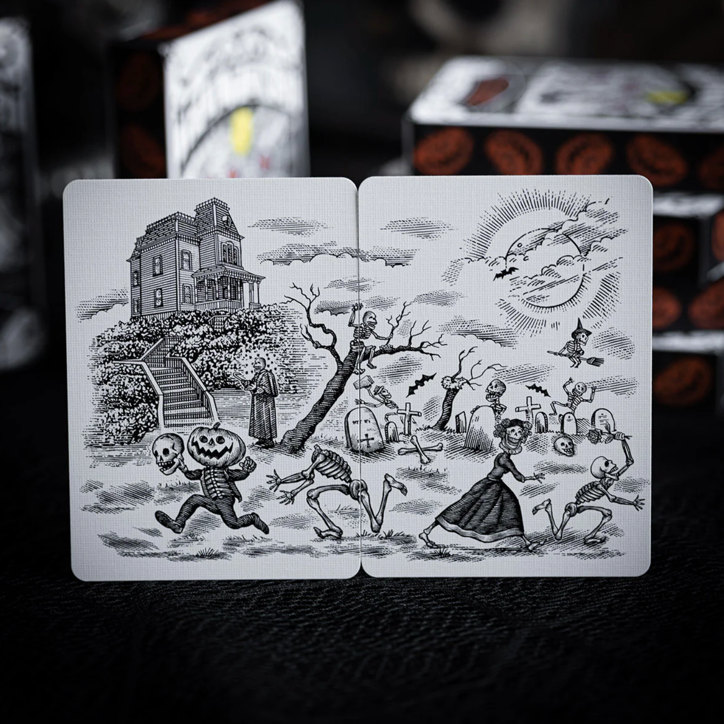 Halloween-themed playing cards with black and white illustrations on a dark background.