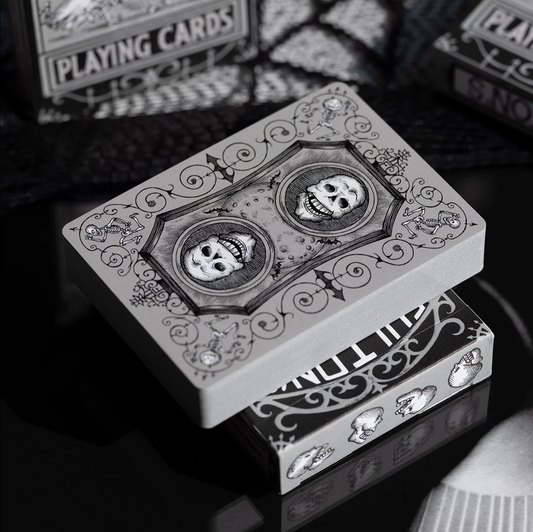 Stack of playing cards with skull design on a reflective surface