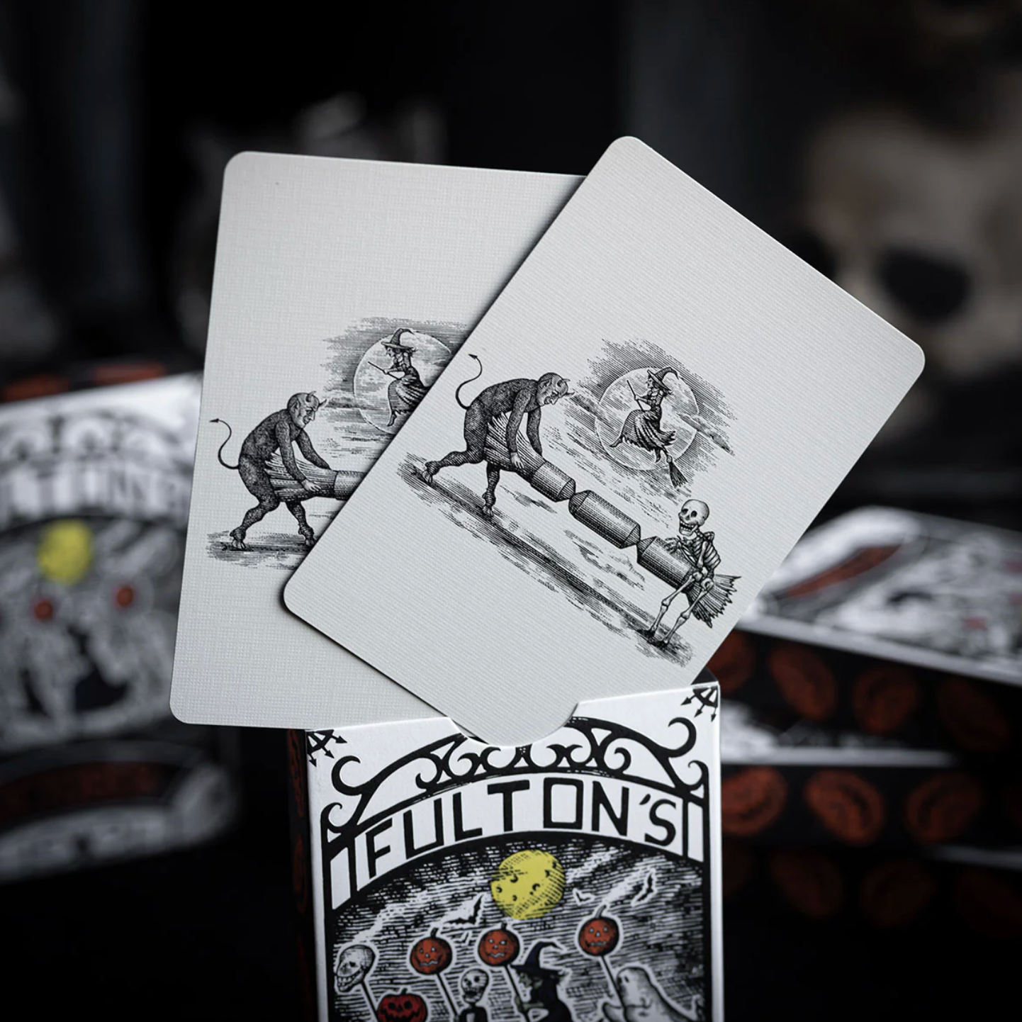 Playing cards with black and white illustrations on a dark background