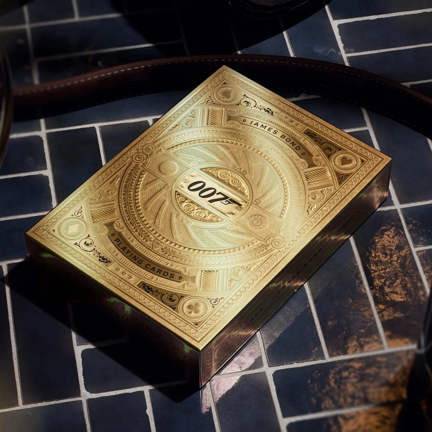 Gold 007 playing card box on a dark tiled surface