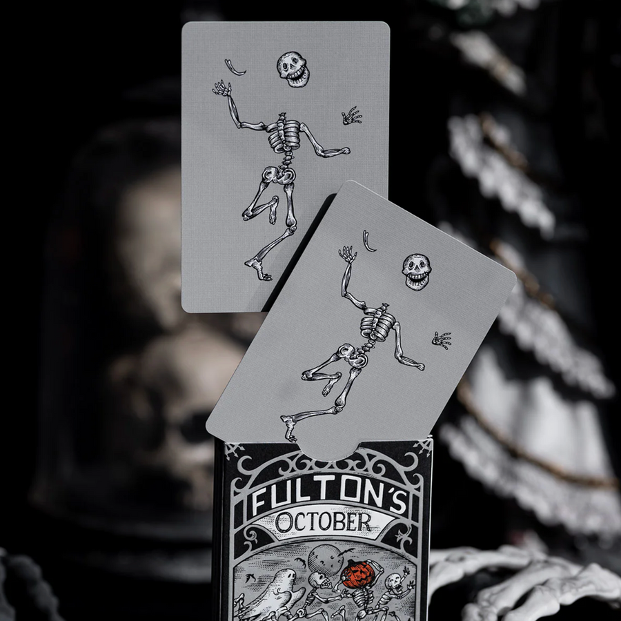 Playing cards with skeleton design and 'Fulton's October' branding on a dark background.