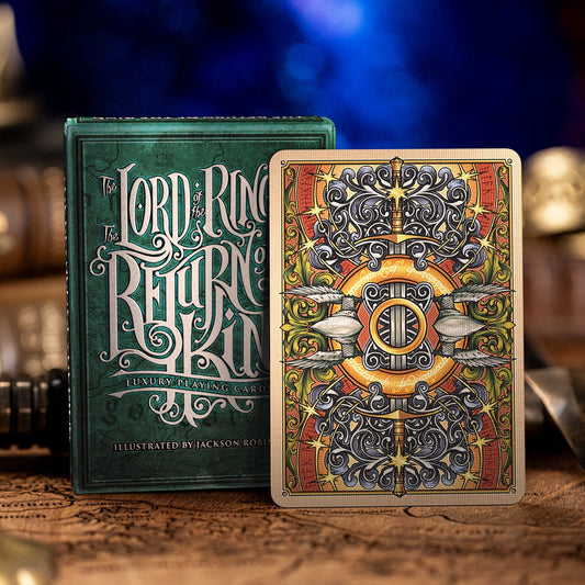 Lord of the Rings playing cards with ornate design on a wooden surface.