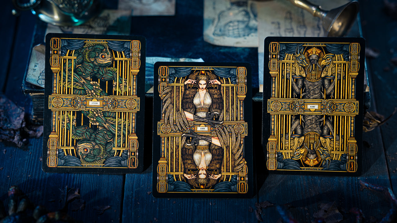 Three tarot cards with ornate designs on a dark blue background