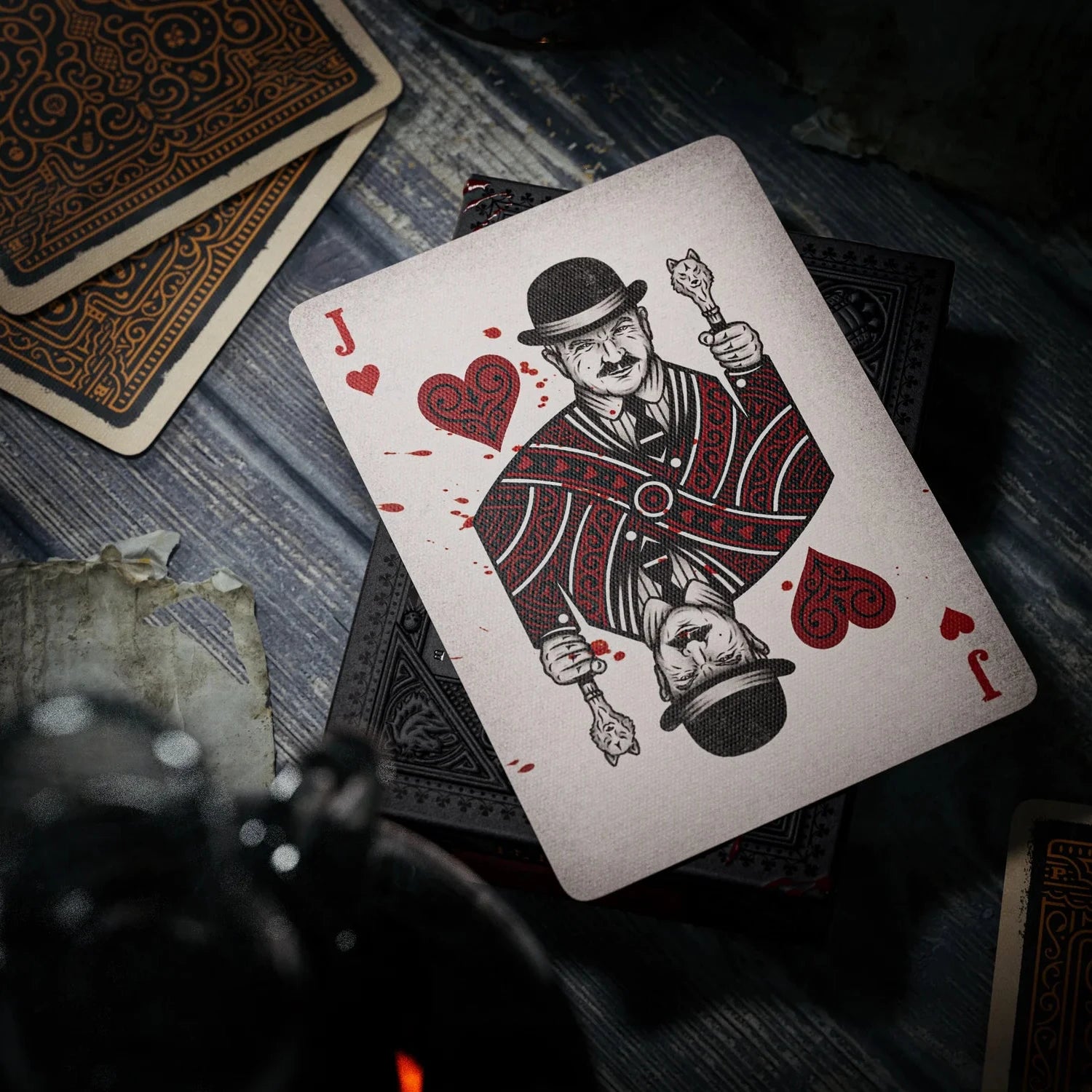 Playing card with a design of a man holding a heart and a sword on a wooden surface.