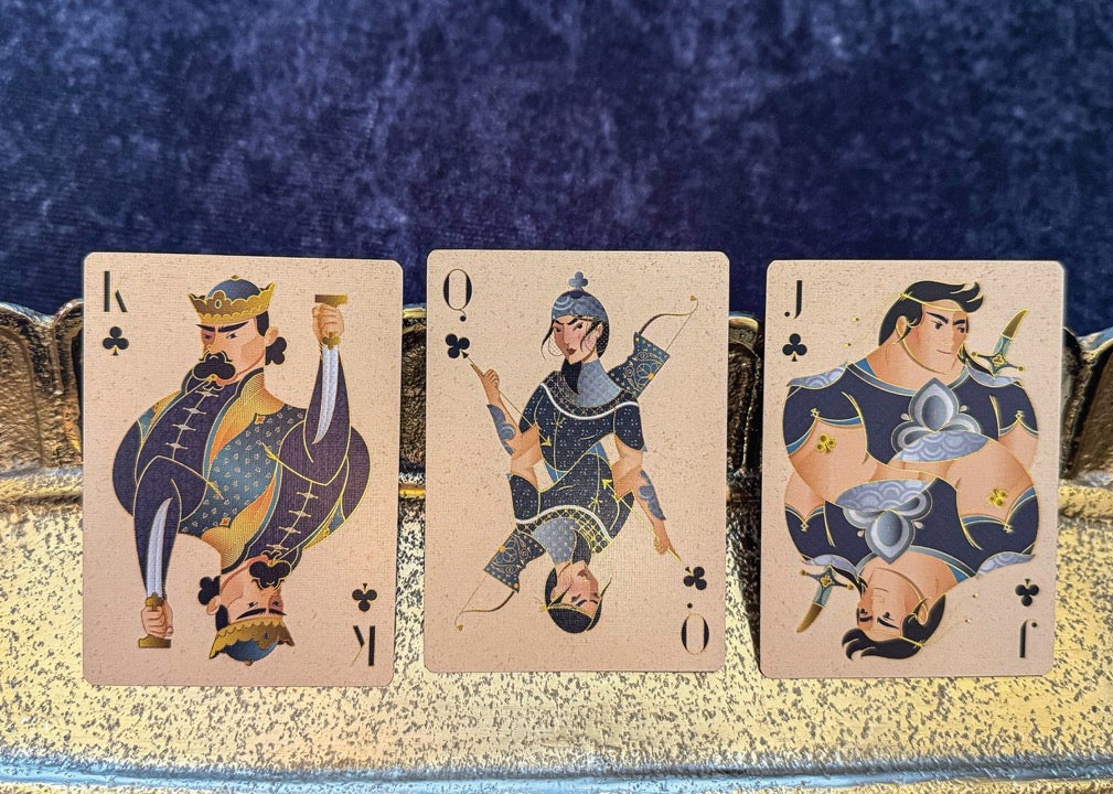 Three playing cards featuring kings on a decorative tray with a blue textured background
