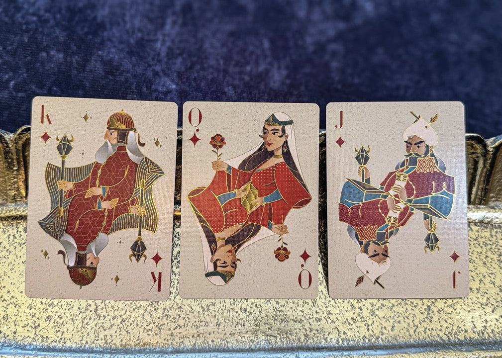 Three playing cards featuring kings on a decorative tray with a blue background