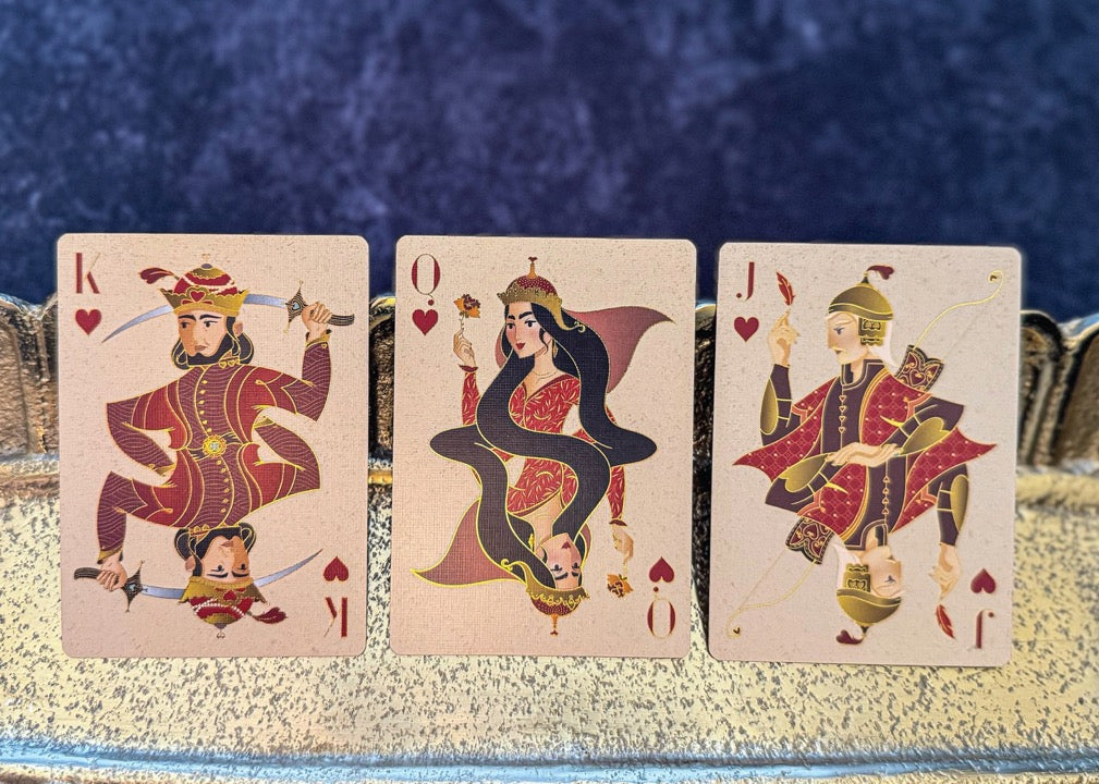 Three playing cards featuring kings on a decorative tray with a blue background