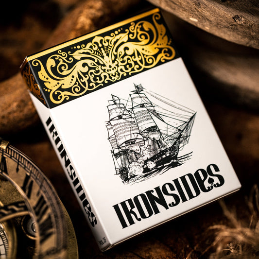 Playing card box with 'Ironsides' branding and ship illustration, surrounded by wooden elements and a compass.