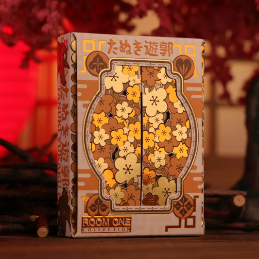Card game box with floral design and text on a blurred background