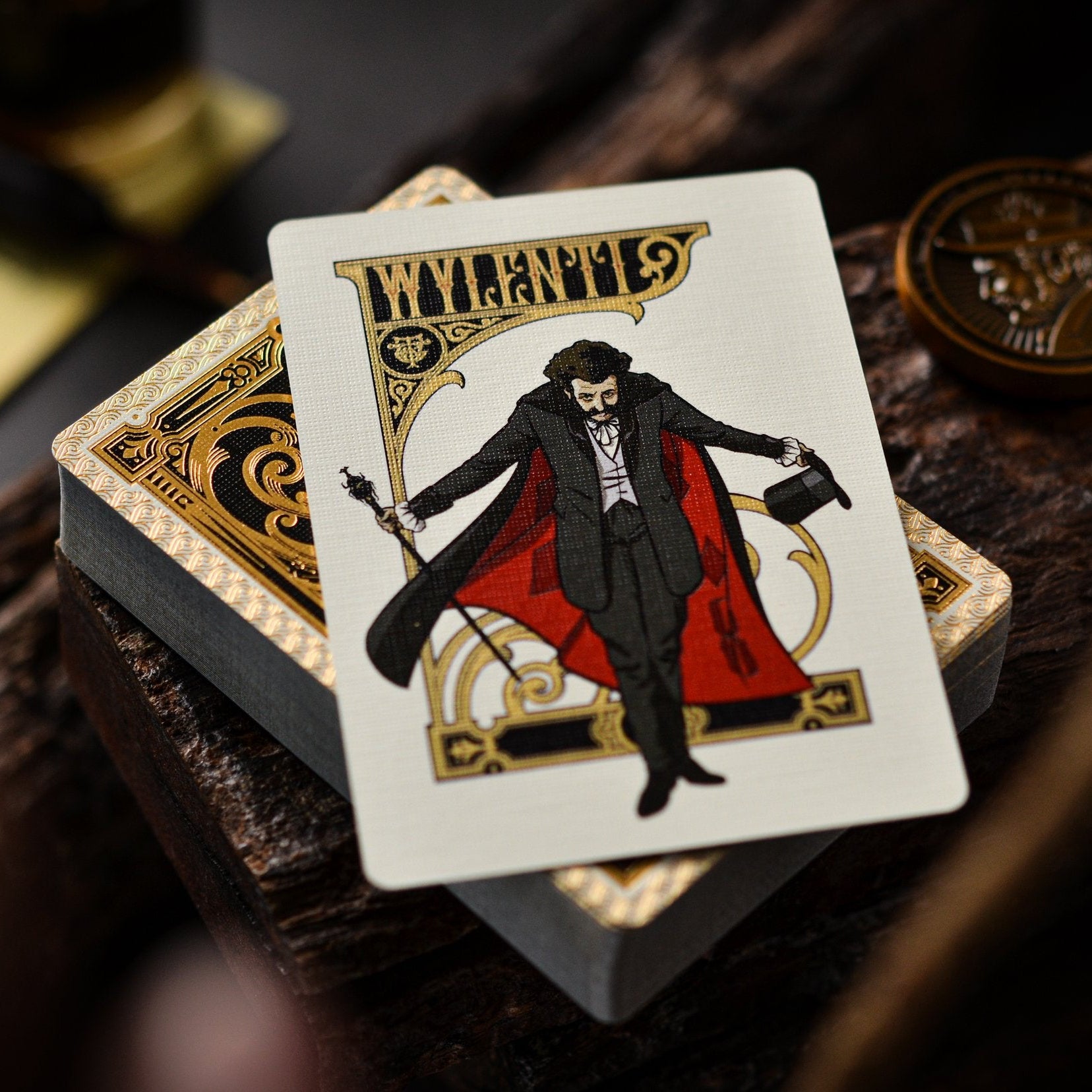 Playing card with a character in a red cape and black coat on a wooden surface.
