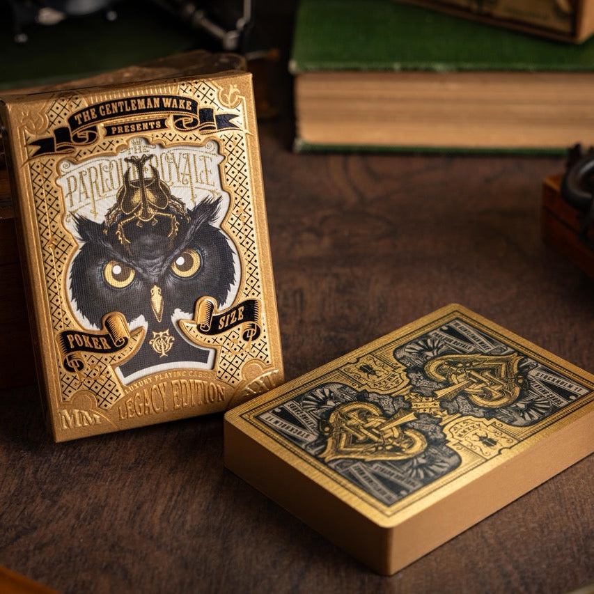 Parlour Royale Legacy Edition Playing Cards are Gold and black playing cards with intricate designs on a wooden surface.