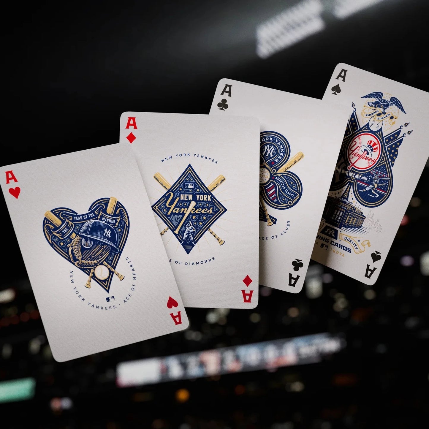 Four playing cards with unique designs on a blurred background